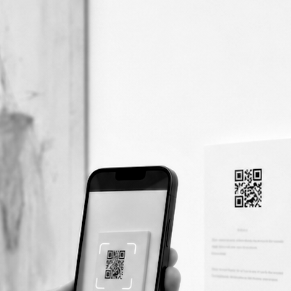 un visiteur scanne un QR code à proximité d'une oeuvre d'art en exposition